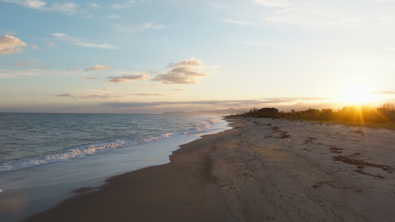 romántico atardecer en el solsticio de invierno en el océano con olas hacia la playa aérea