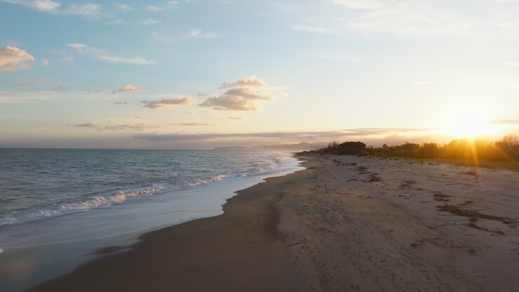 ロマンチックな夕暮れ 冬至の海で 波がビーチに向かって