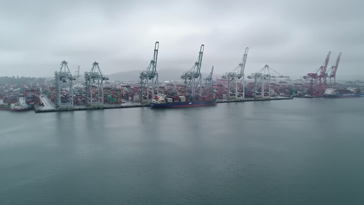 Aerial Views of a Busy Port: Container Ships, Cranes, and Fog Shrouded Waterfront Operations Captured in Two Distinct Frames