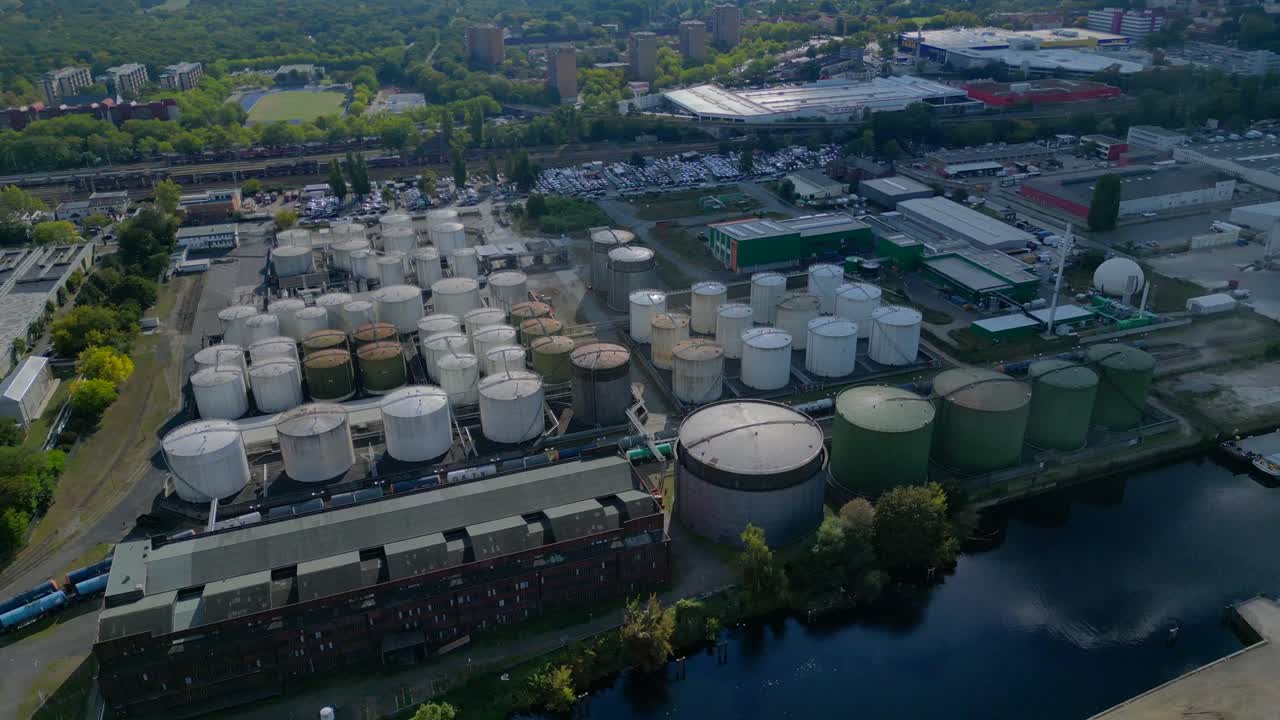 Berlin biogas plant with storage tanks by Spree river, producing renewable energy. Nice aerial view flight panorama orbit drone