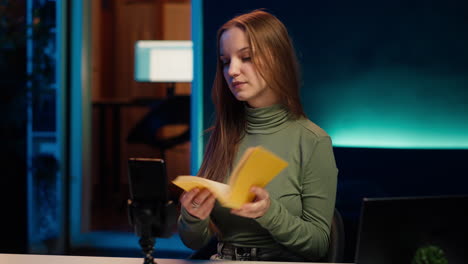 joven creador de contenido películas video revisión de libro, navegando por las páginas