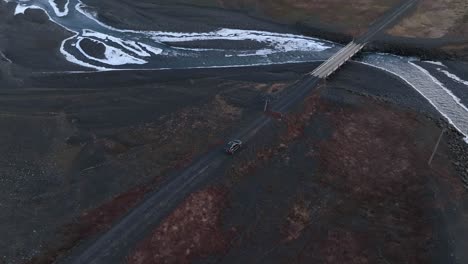 aerial view of a car crossing a bridge over a river