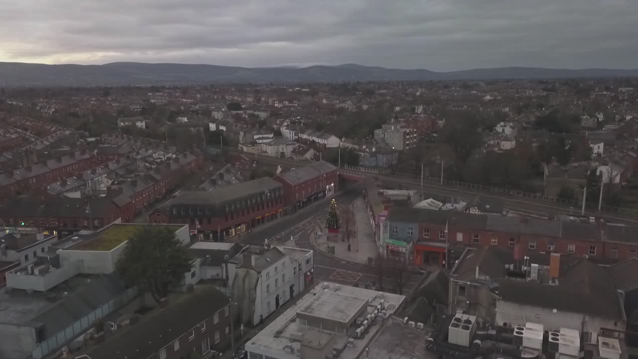 Pedestal down (Drone shot) in Ranelagh of the old triangle at Christmas time and Dublin Dublin Mountains in the background(early in the morning)