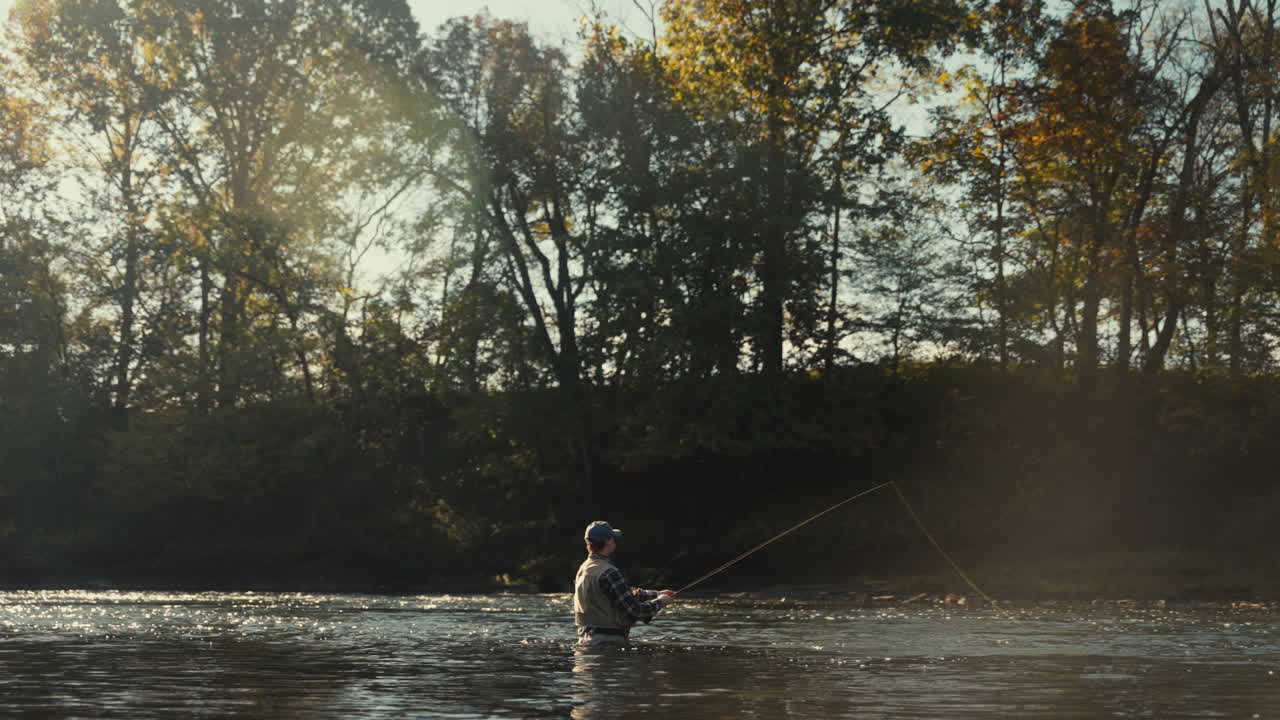 Uomo che pratica la pesca a mosca in un fiume tranquillo