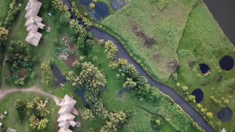 Drone-flying-above-houses-and-trees-and-river-at-sunset-in-Hanalei-valley-in-Kauai,-Hawaii