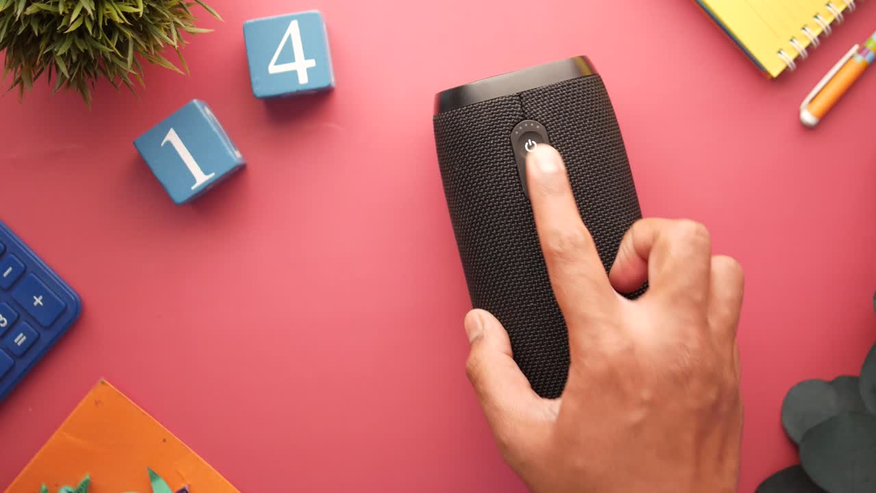 persona que enciende un altavoz portátil