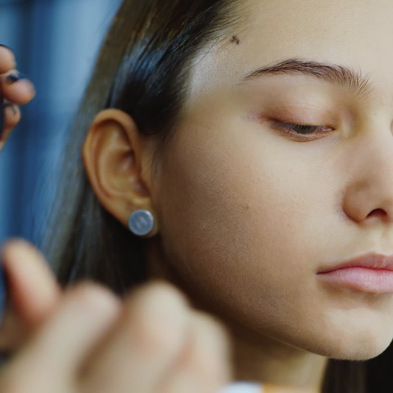 el maquillador hace el maquillaje de una mujer joven en el estudio 1