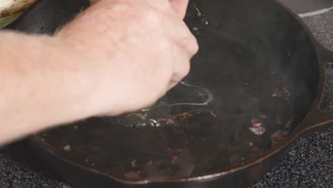 romper el huevo en una sartén de hierro fundido caliente en la estufa