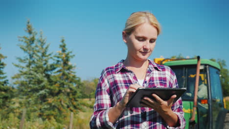 a young female farmer uses a tablet in a field technology in agriculture