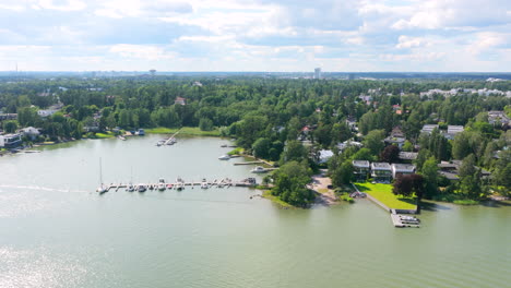 aerial tracking shot in front of seaside villas and docks of westend, finland