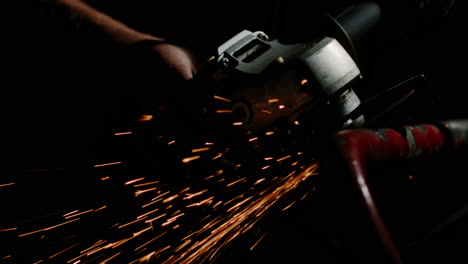 sparks fly as the man cuts through the material with a grinding tool, skillfully operating the angle grinder