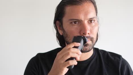 Latino-man-trimming-beard-and-mustache-with-electric-razor,-Shaving-cream