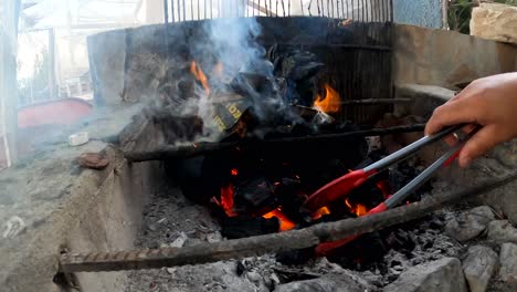 charcoal fire is set ablaze on rebar and concrete stove area