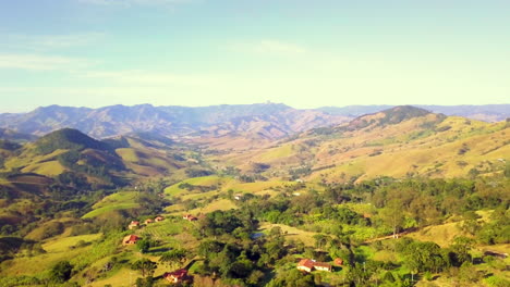 aerial ascending view over rural houses into mantiqueira mountains in sao bento do sapucai, sao paulo, brazil