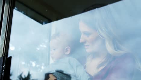 mother with her baby standing near window 4k