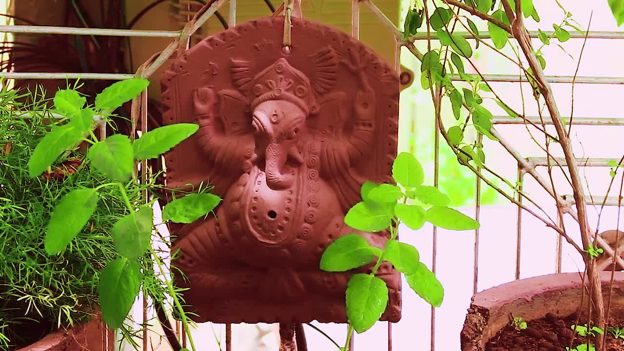 estatua del dios hindú ganesha aislada en el jardín con árbol de tulsi para orar durante el día
