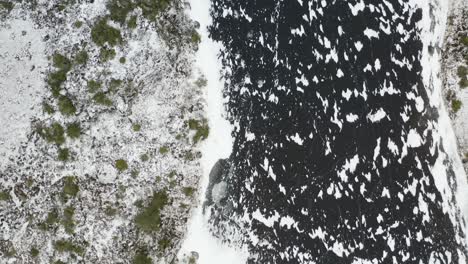 Aerial-shot-of-a-landscape-covered-in-snow-and-frost-in-winter