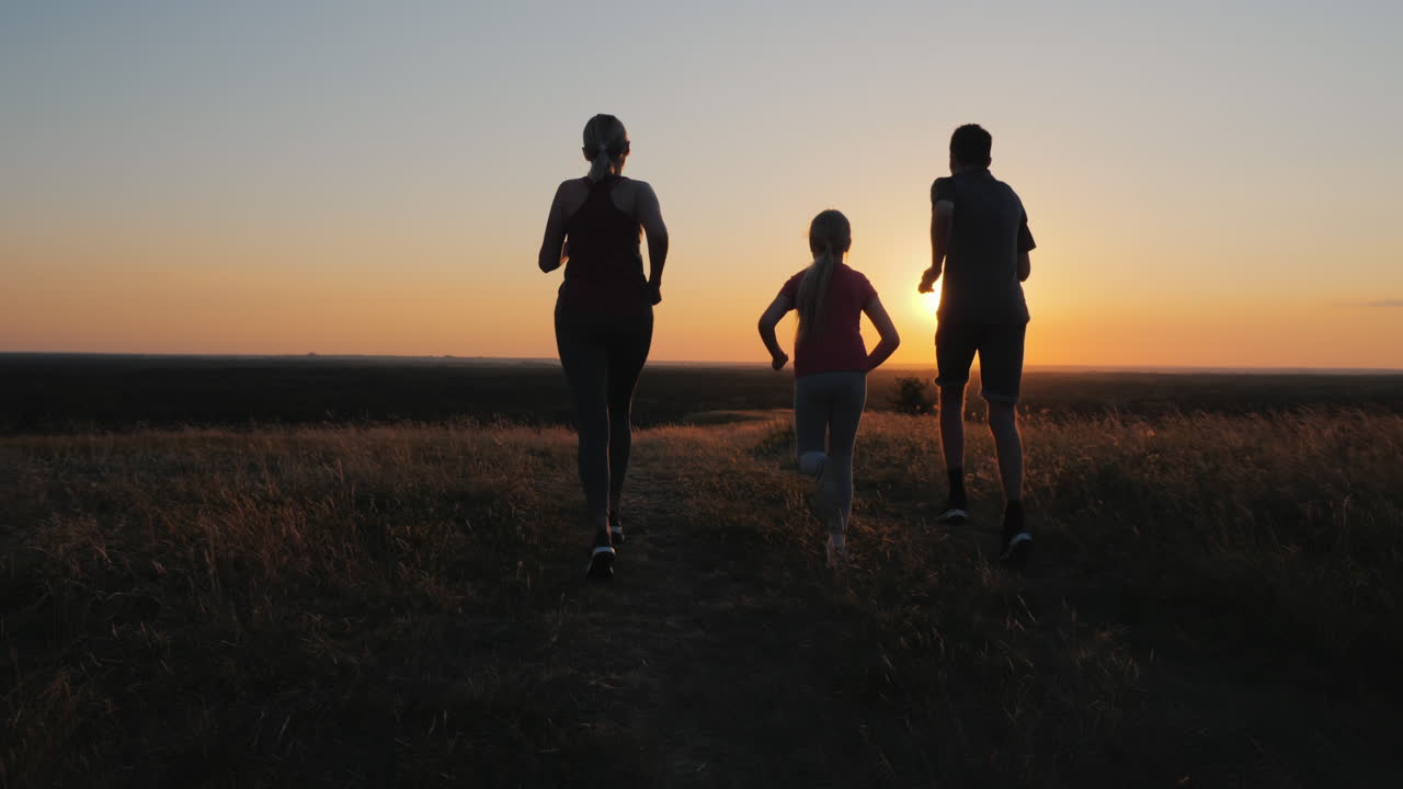 Un bambino piccolo con una coppia che fa jogging all'aperto in un luogo suggestivo al tramonto