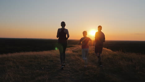 A-Young-Niño-With-A-Couple-Jogging-Outdoors-In-Scenic-Location-On-The-Sunset