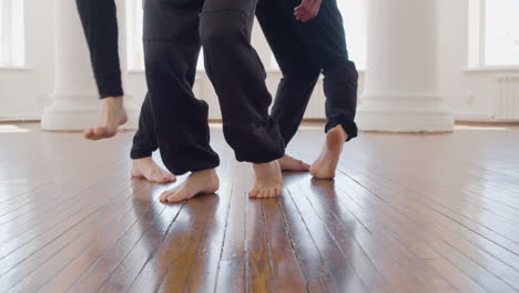 Primer-Plano-De-Las-Piernas-De-Tres-Bailarines-Contemporáneos-Entrenando-Movimientos-De-Baile-En-El-Estudio