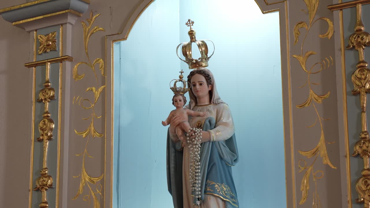 Statue of Virgin Mary holding Baby Jesus with ornate gold details