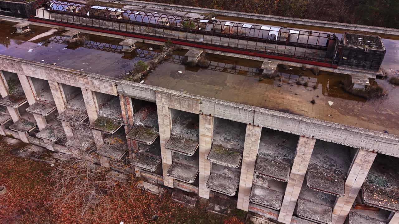 Abandoned industrial building with water pooling on rooftops in autumn