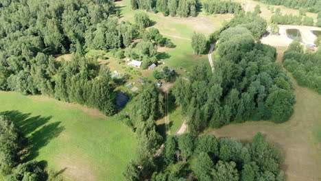 Schönes-Altes-Gehöft,-Umgeben-Von-Wald-Und-Wiese,-Absteigender-Luftblick