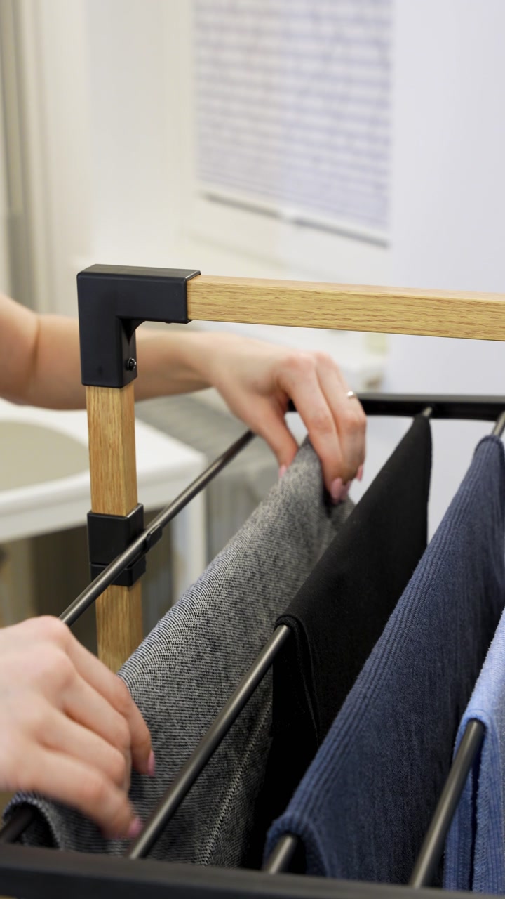 A woman hanging clothes on the clothesline. Vertical close-up