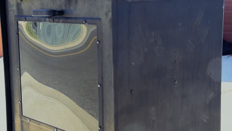 una vieja caja de periódicos pintada de negro sin periódico