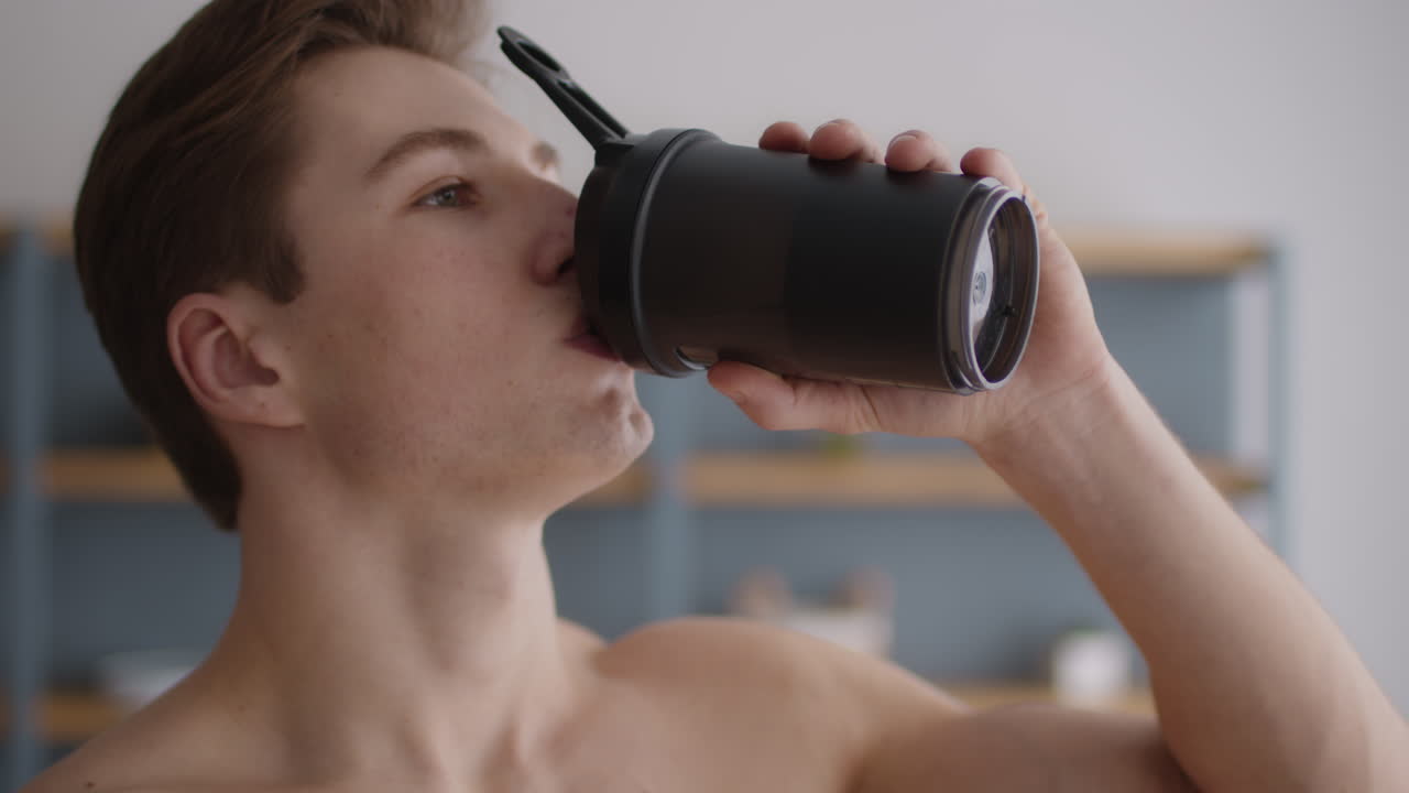 hombre bebiendo batido de proteínas y feliz