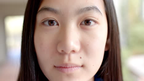close-up of a teenage asian girl with long dark hair and a subtle smile