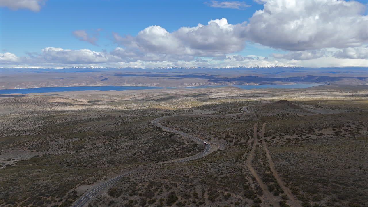 Stunning view of the street, route 237, Embalse Piedra del Aguila and Andes mountains, cloudy day, truck shot, slow motion and copy space