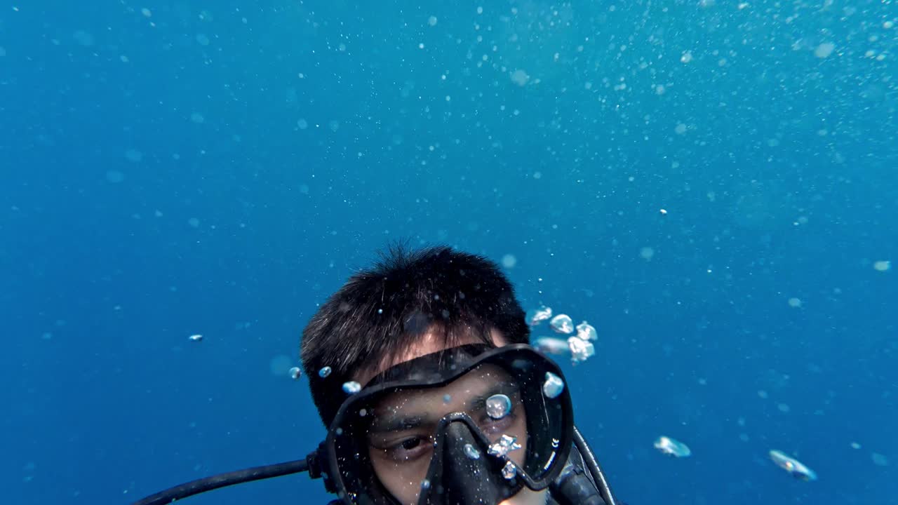 A lone scuba diver completes a calm, controlled ascent from a 5 m safety stop in the crystal‑clear waters of the Maldives.
