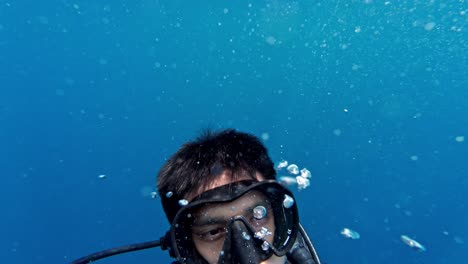 a lone scuba diver completes a calm, controlled ascent from a 5 m safety stop in the crystal‑clear waters of the maldives.