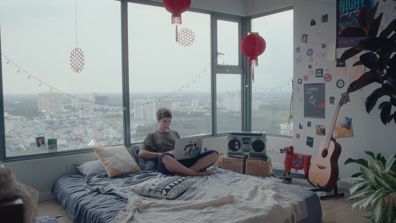 침실에서 노트북으로 일하는 젊은 여성