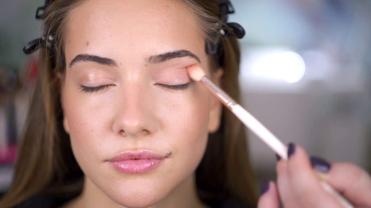 Woman getting eyeshadow applied with a brush