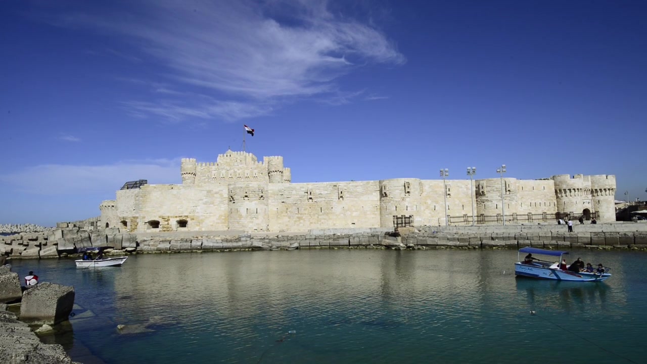Cittadella di Qaitbay ad Alessandria, Egitto. Un uccello passa. Castello sullo sfondo.