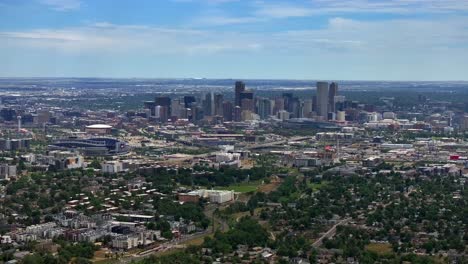 Summer-downtown-Denver-Colorado-aerial-drone-Mile-High-city-skyscrapers-neighborhood-homes-blue-skies-cloudy-6th-avenue-colfax-RTD-line-front-range-foothills-landscape-forward-up-motion