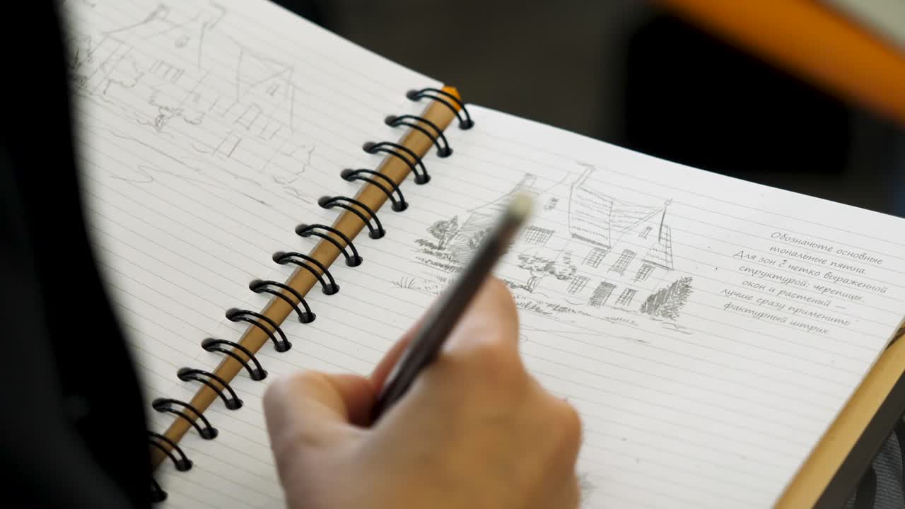 나선형 노트북에서 스케치하는 사람