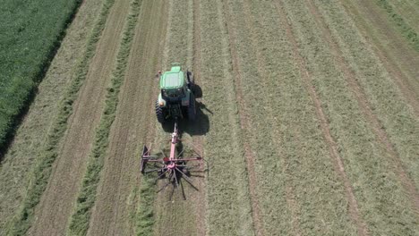en un campo agrícola en el sudoeste de wisconsin, un agricultor rastrilla el heno con un rastrillo giratorio para heno-8