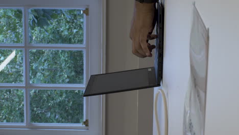 oficina masculina de minoría étnica escribiendo en una computadora portátil en la mesa de la oficina al lado de la ventana