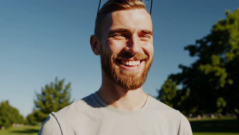 a man smiling happily outdoors in a park