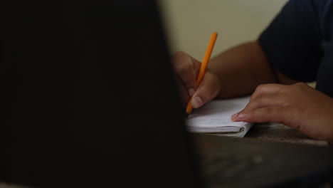 person studying for exams by writing down notes