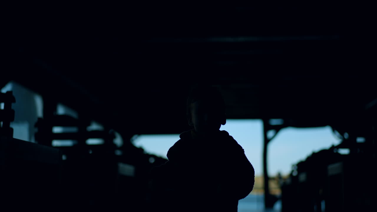 Silhouette of a toddler running up to camera. Little kid in the premise near the river.