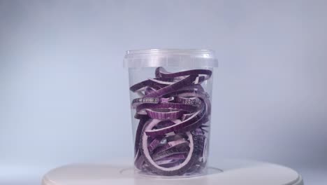 a clear jar filled with freeze-dried onion rings, showcasing their vibrant purple and white hues. perfect for cooking, garnishing, or long-term storage.