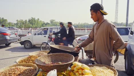 vibrant street scene in islamabad, pakistan, featuring a popular vendor expertly grilling fresh corn seeds on the cob for eager customers.