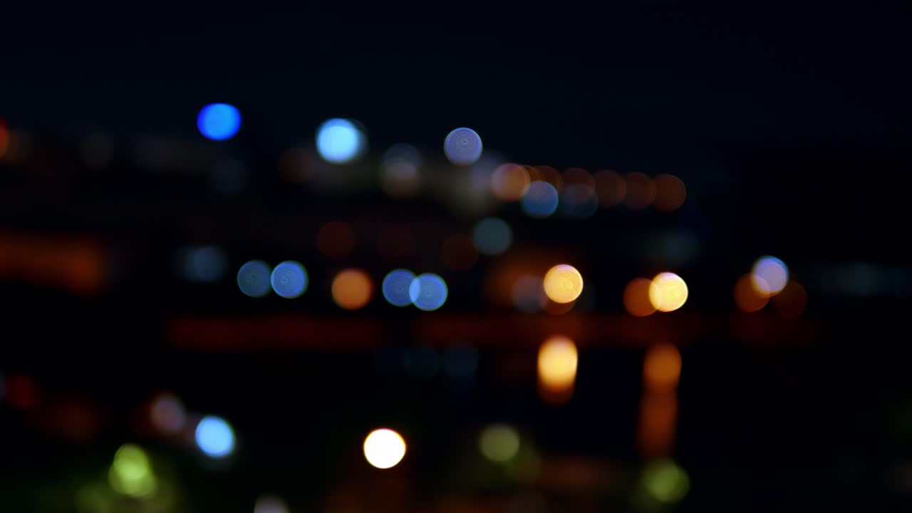 bokeh de fondo de rascacielos en la ciudad con luces y círculos de colores borrosos en la noche