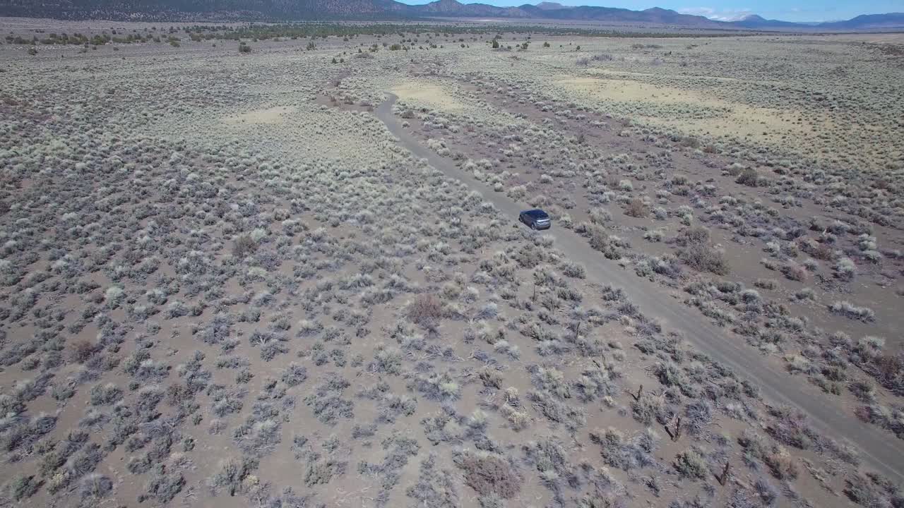 antena encima de un 4wd viajando por un camino de tierra en el desierto de mojave con las montañas de sierra nevada distantes 2