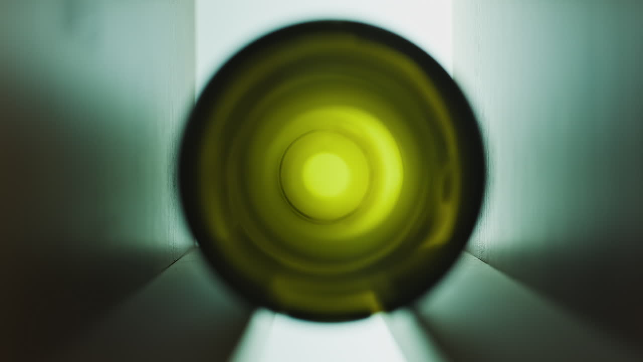 Close up of the bottom of an empty, green, wine bottle on a shelf