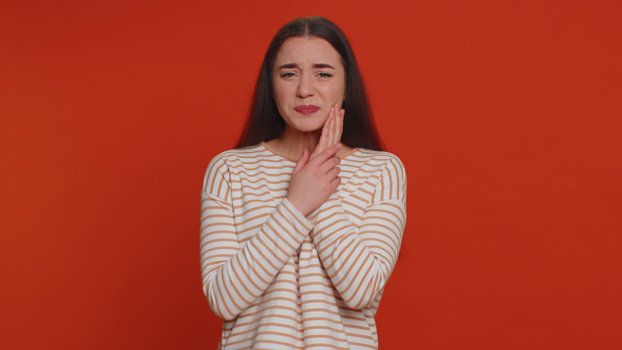 mujer tocando la mejilla que sufre de dolor de muelas, caries o gingivitis esperando una cita con el dentista